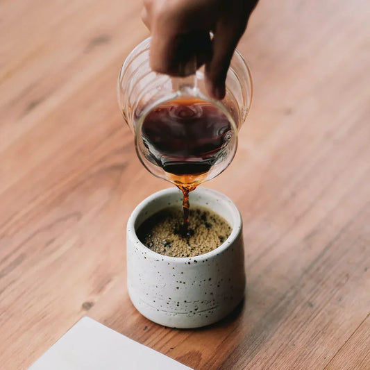 Taza de café negro sobre superficie oscura